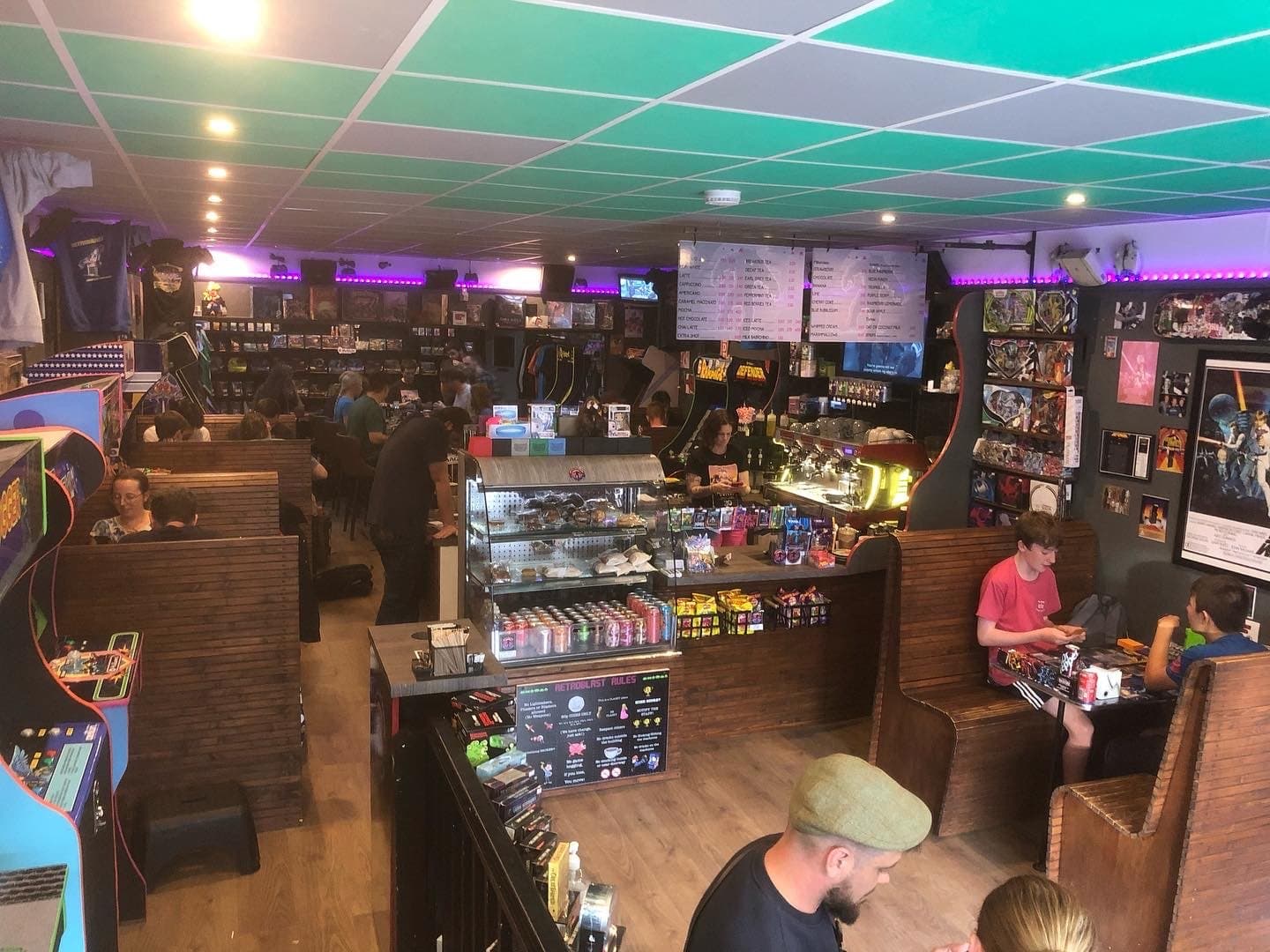 Wide interior — booth seating, counter and chalkboard menu under purple LED strips