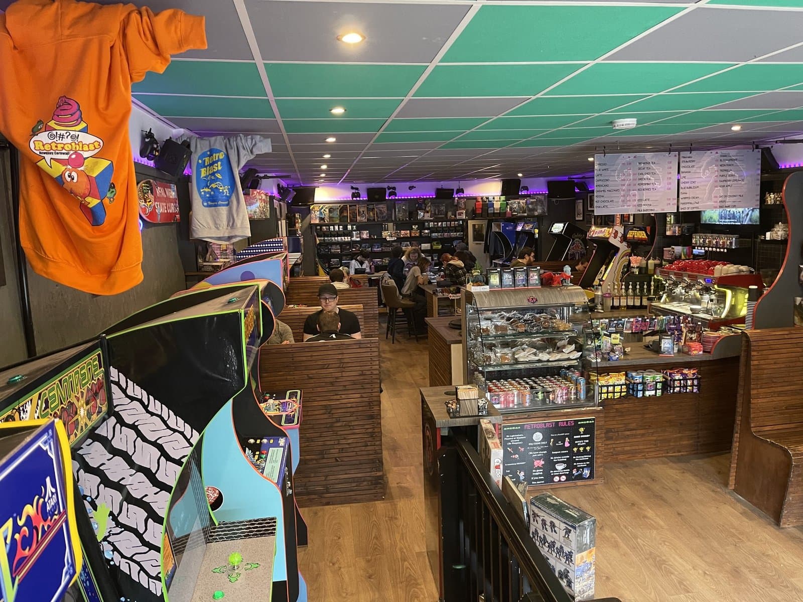 Daytime interior — RetroBlast tee on display, original arcade cabinets and quiet booths