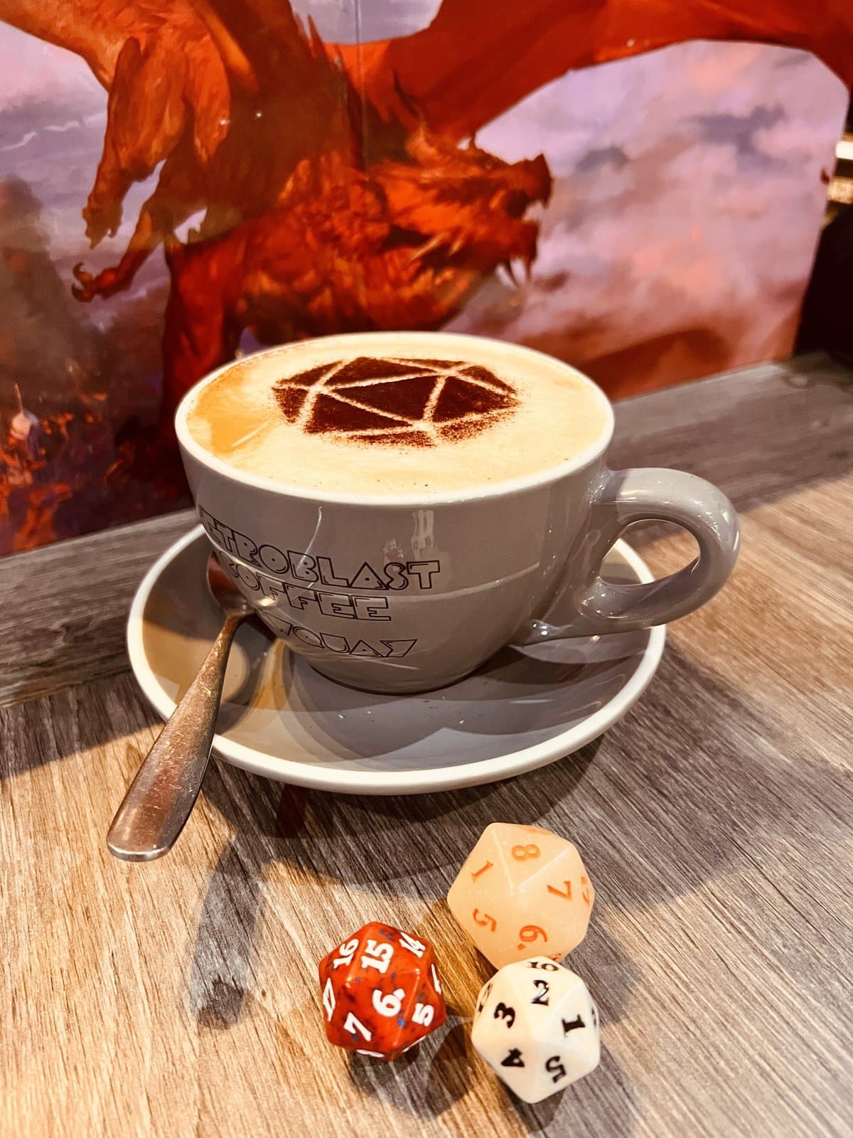 Mocha with a D20 dice icon dusted in cocoa, served in a RetroBlast mug beside D&D dice