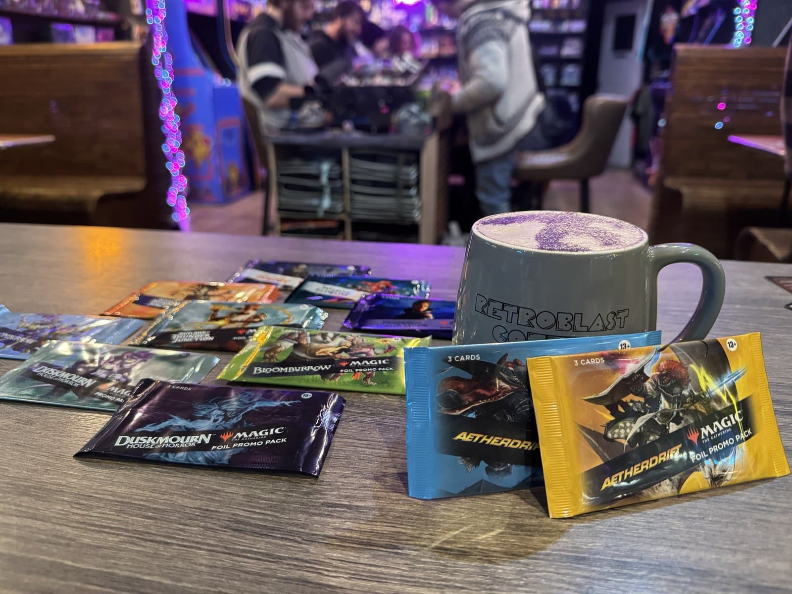 Magic: The Gathering Aetherdrift boosters and a RetroBlast mug on a wooden table